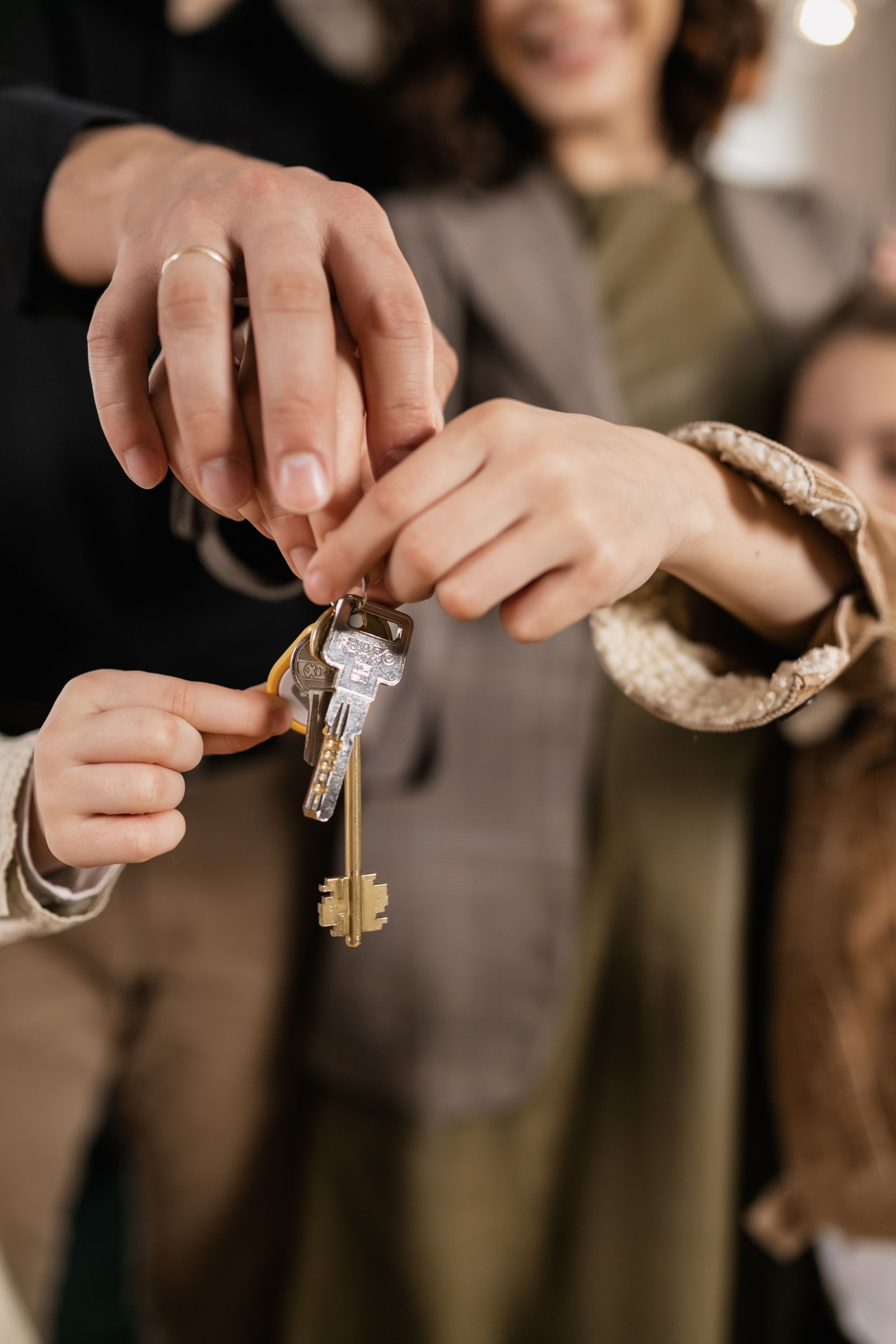 A family holding the keys to their new home together